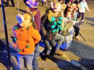 Kids try to grab a bite of doughnut at Light Up Brookhaven