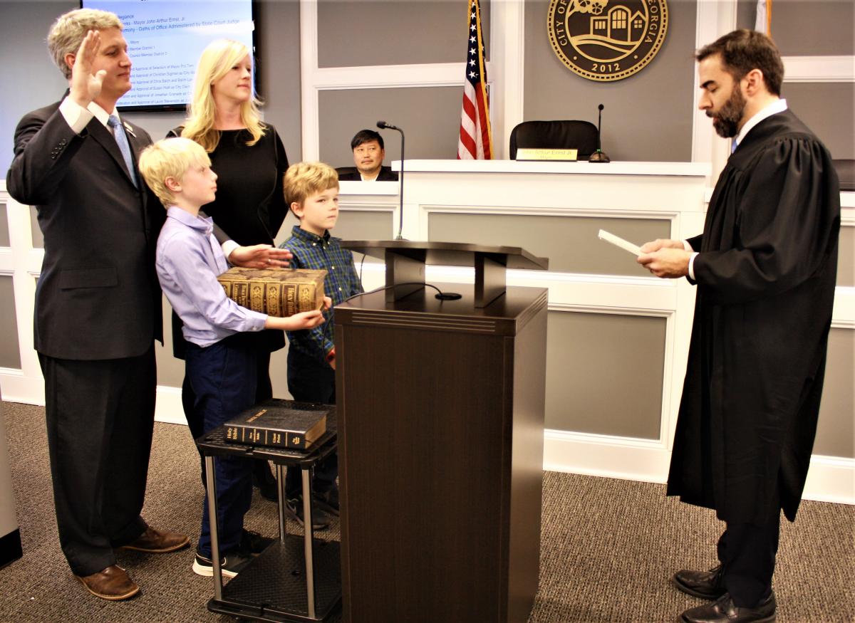 Brookhaven Mayor John Ernst is sworn into a new term as his wife, Monica Vining, and sons, Jack and Evan, look on.